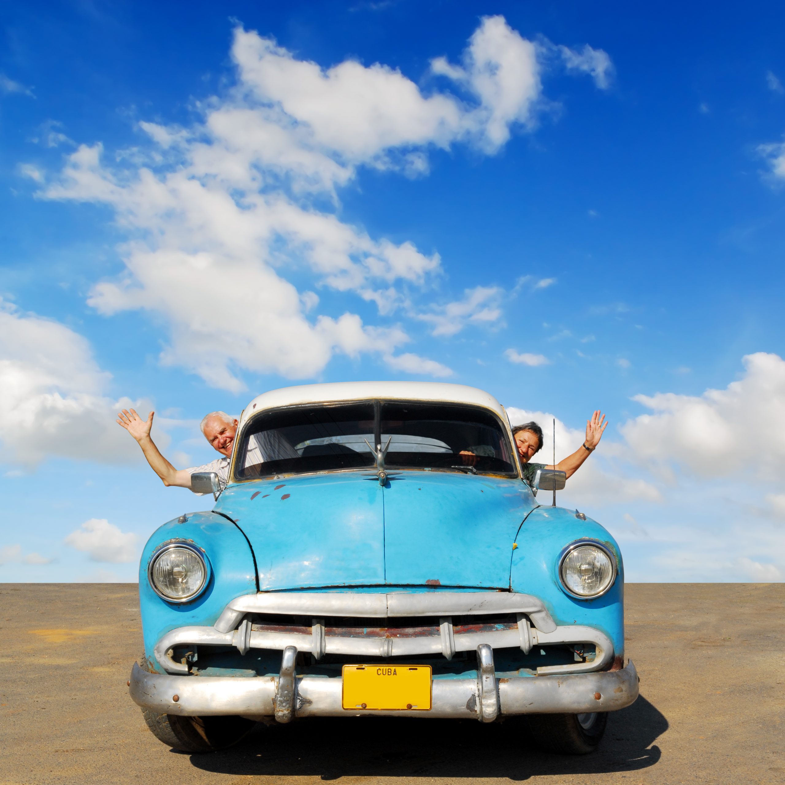 European senior couple having fun touring around Cuba, in an blu