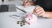 Woman Putting Golden Coin In Pink Piggy Bank For Step Up Growing