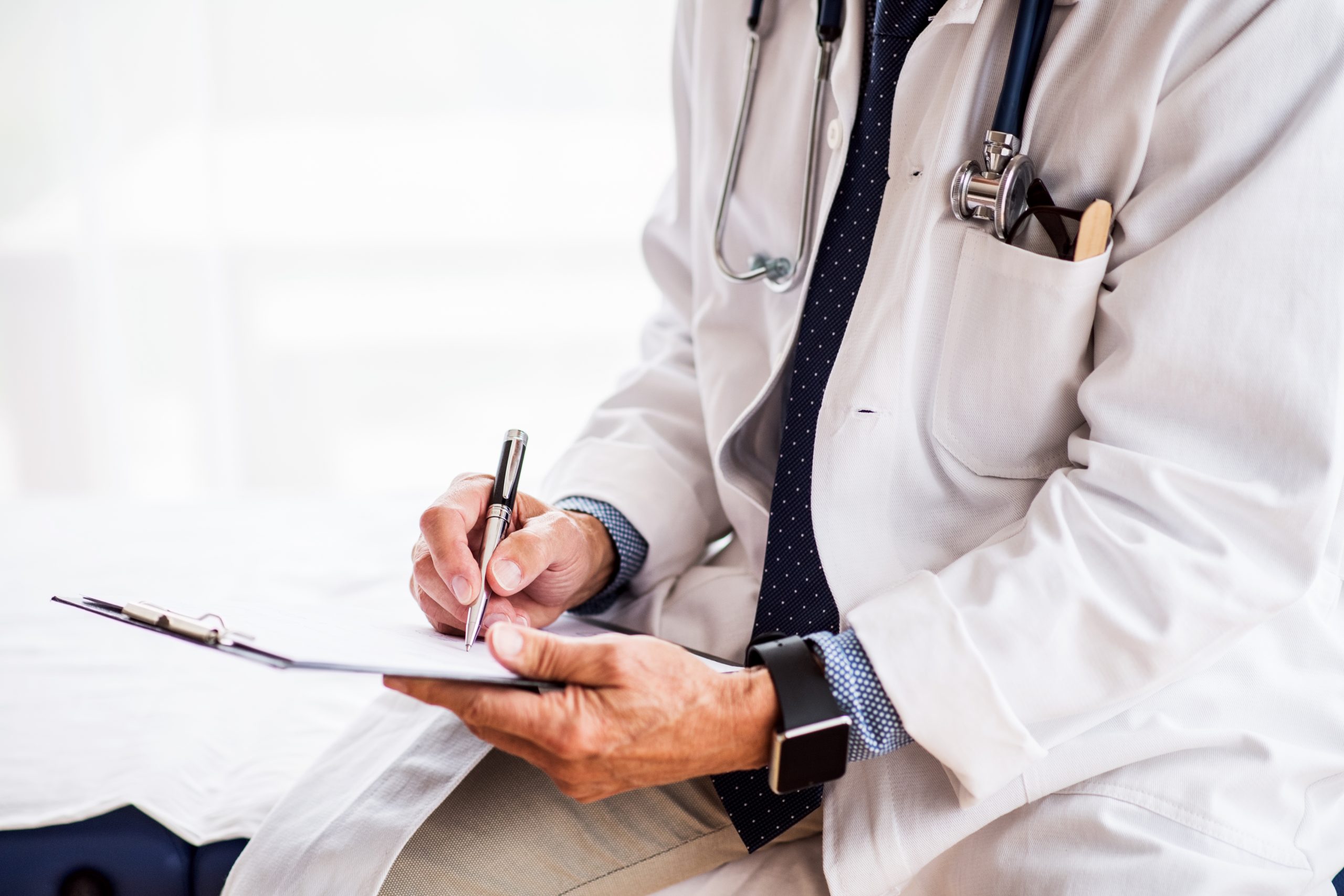 Senior doctor with smartwatch in office.